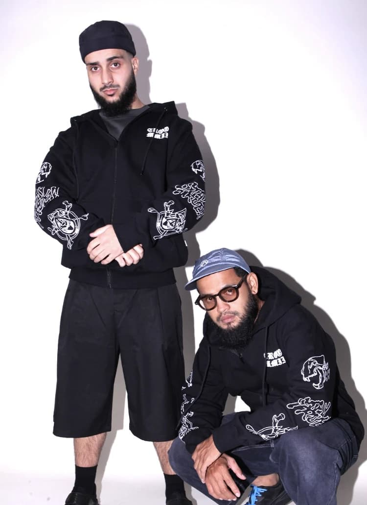 Dua model memakai hoodie MMIII, satu berdiri dan satu jongkok